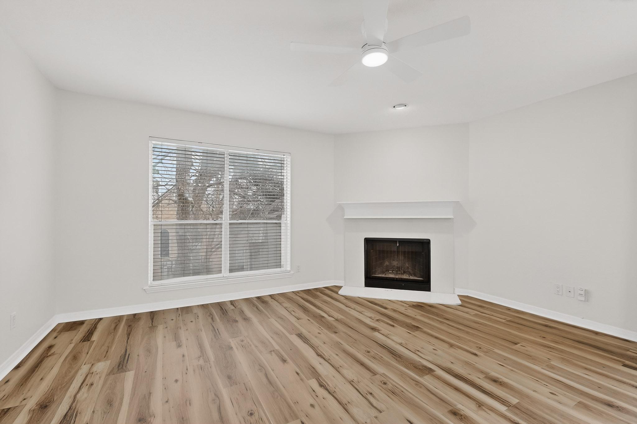 2450 Wickersham Lane, Unit 904 Austin, TX 78741 - Photo 6 of 35 an empty room with wooden floor fire place and windows