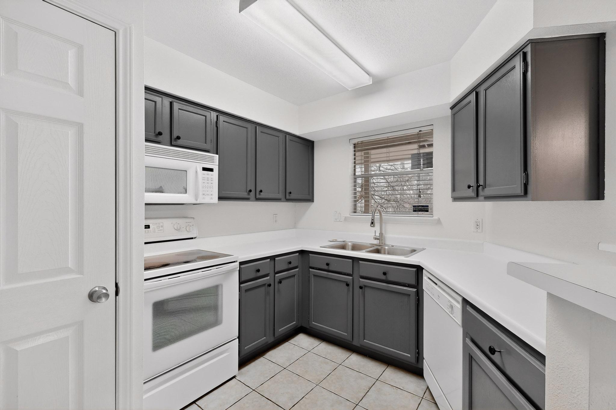 2450 Wickersham Lane, Unit 904 Austin, TX 78741 - Photo 9 of 35 a kitchen with a sink stove and cabinets