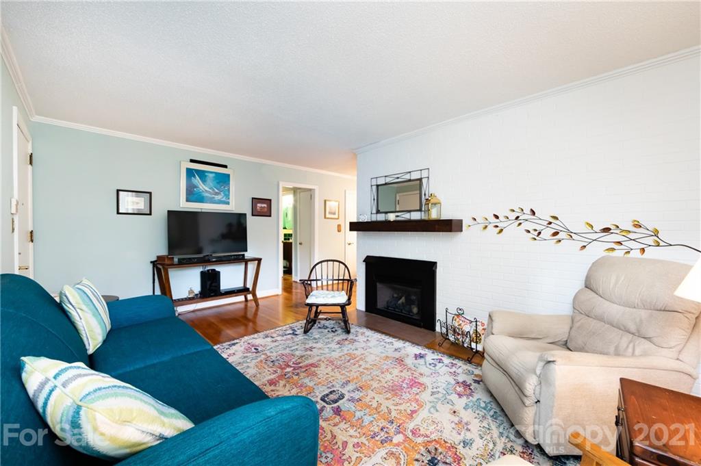 731 Lochridge Road Charlotte, NC 28209 - Photo 2 of 31 a living room with furniture a flat screen tv and a fireplace