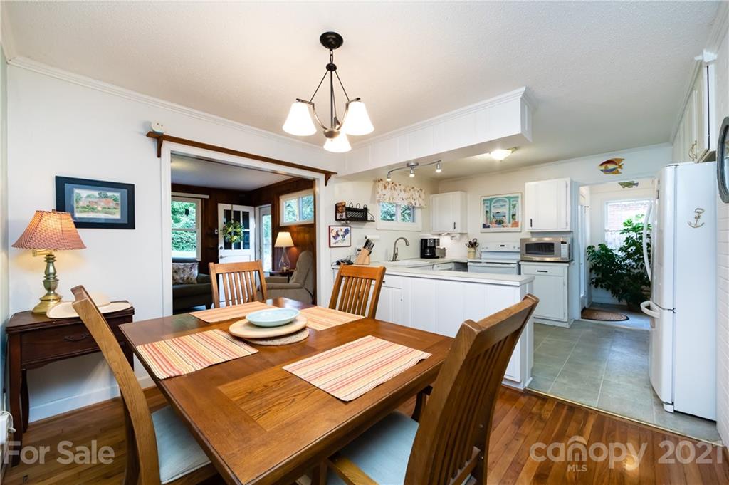 731 Lochridge Road Charlotte, NC 28209 - Photo 5 of 31 a view of a dining room and livingroom with furniture wooden floor a rug a painting and a chandelier