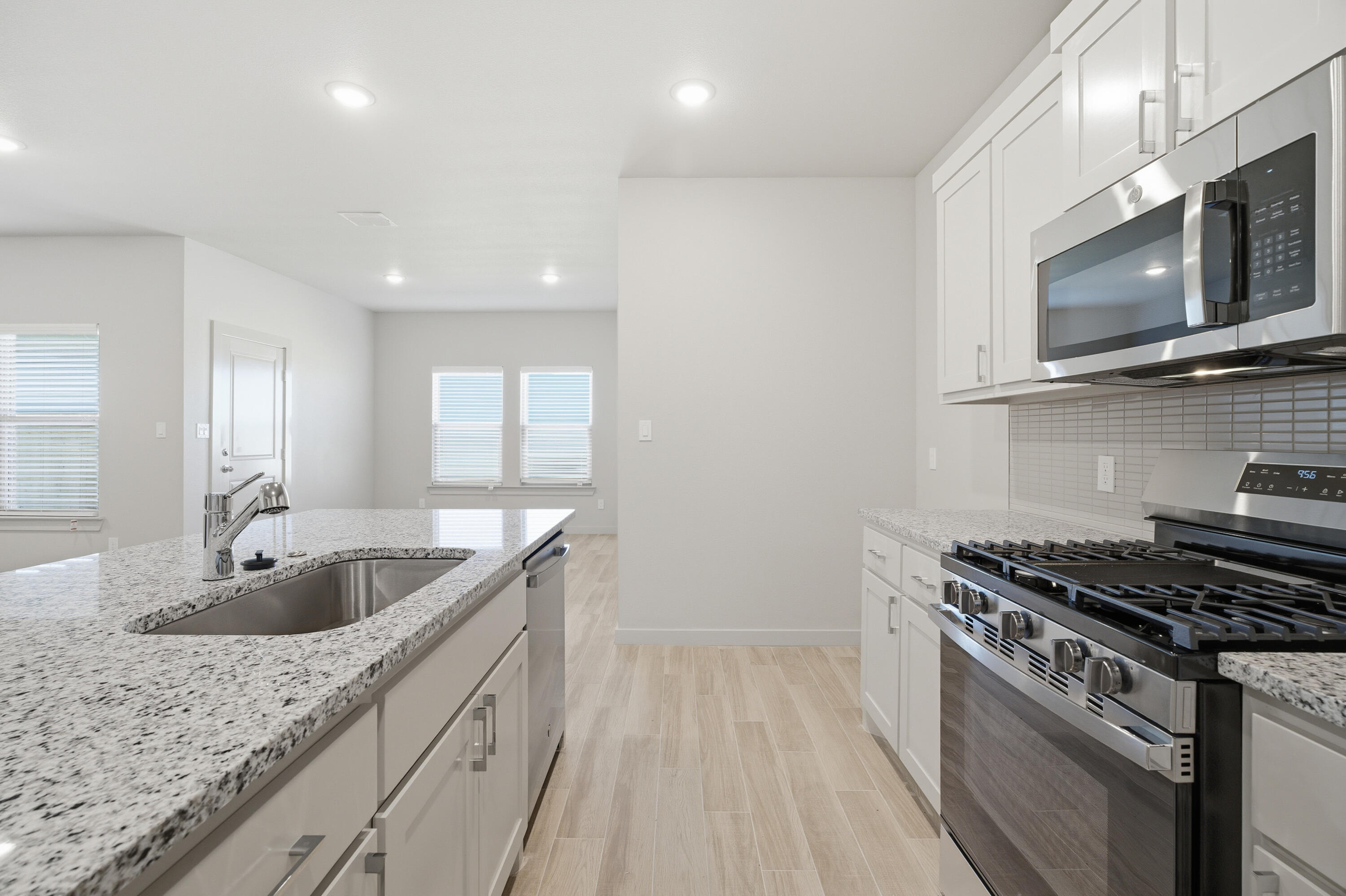 616 East 13th Street Wolfforth, TX 79382 - Photo 12 of 34 a kitchen with granite countertop a sink stainless steel appliances and cabinets