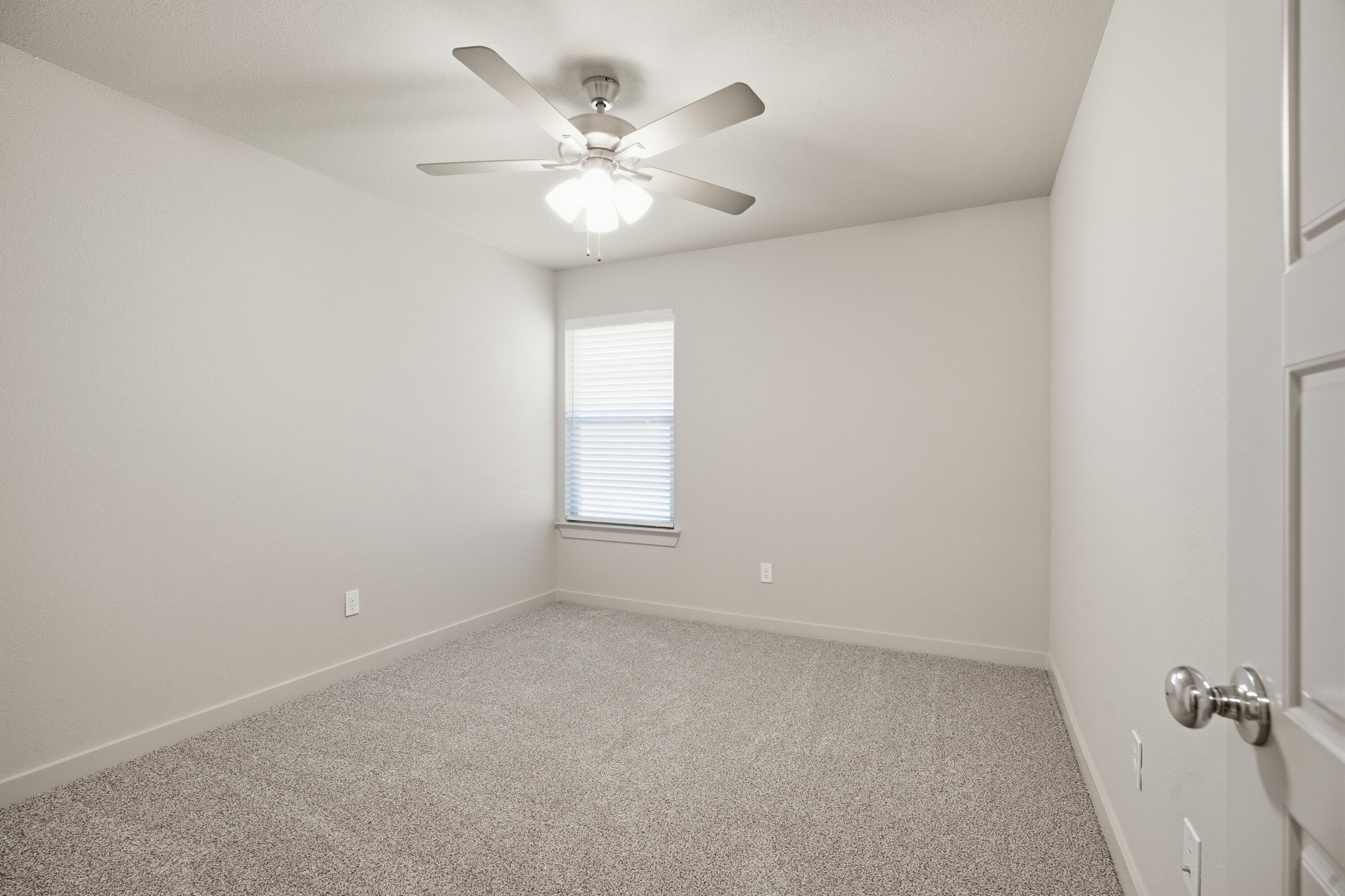 616 East 13th Street Wolfforth, TX 79382 - Photo 26 of 34 an empty room with a chandelier fan and windows