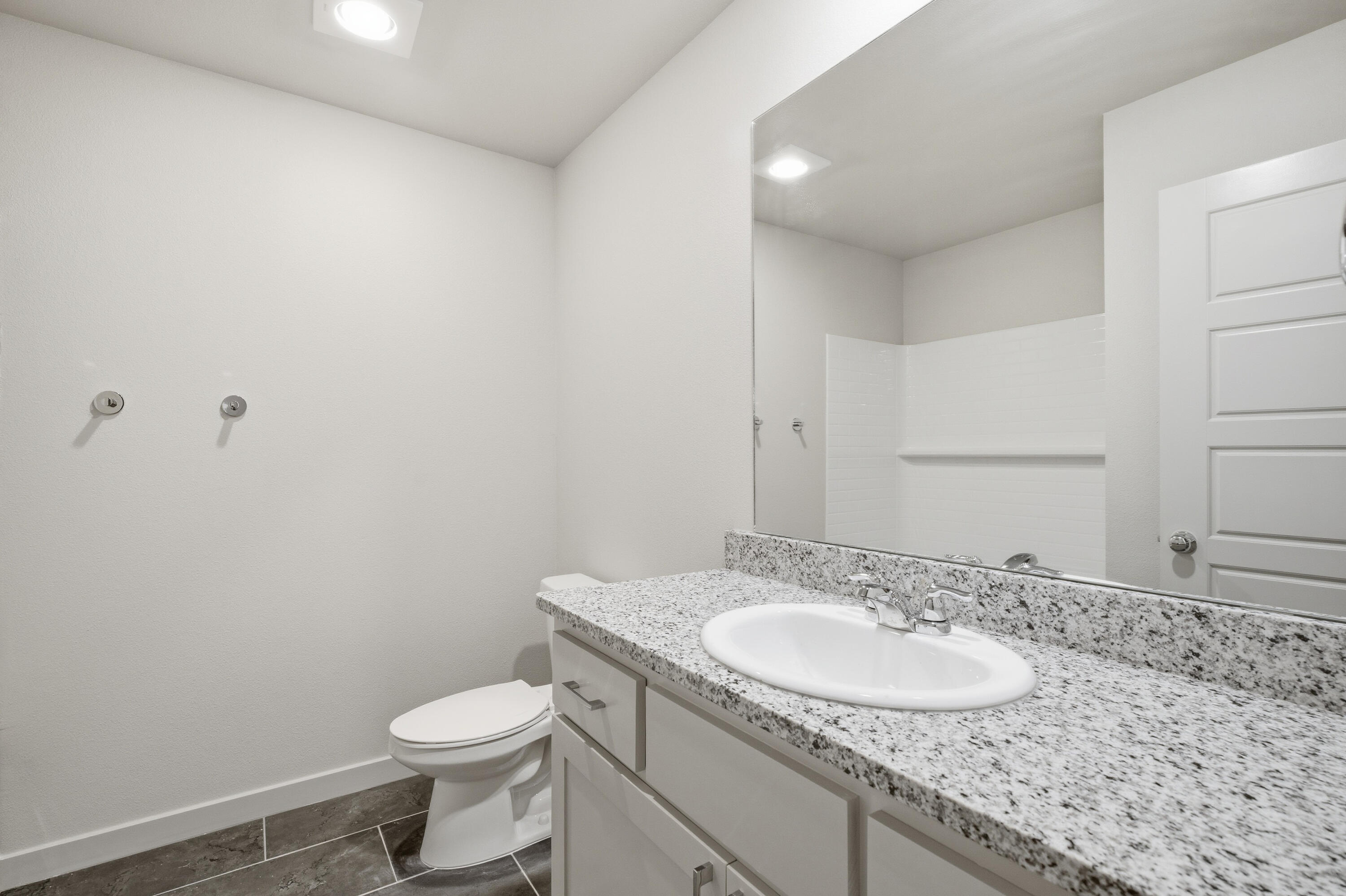 616 East 13th Street Wolfforth, TX 79382 - Photo 28 of 34 a bathroom with a granite countertop sink a toilet and a mirror
