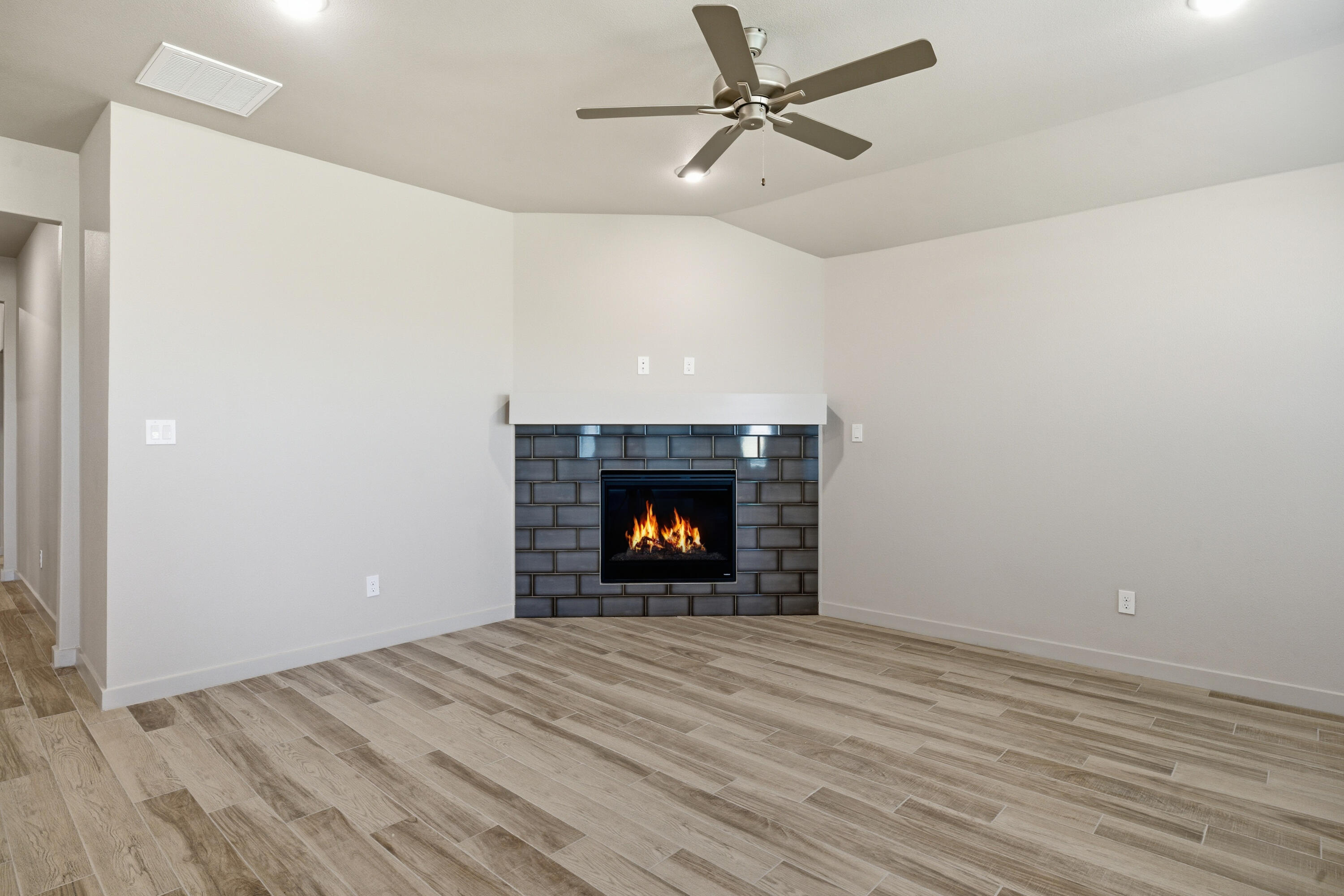 616 East 13th Street Wolfforth, TX 79382 - Photo 4 of 34 a view of an empty room with wooden floor fireplace and a window