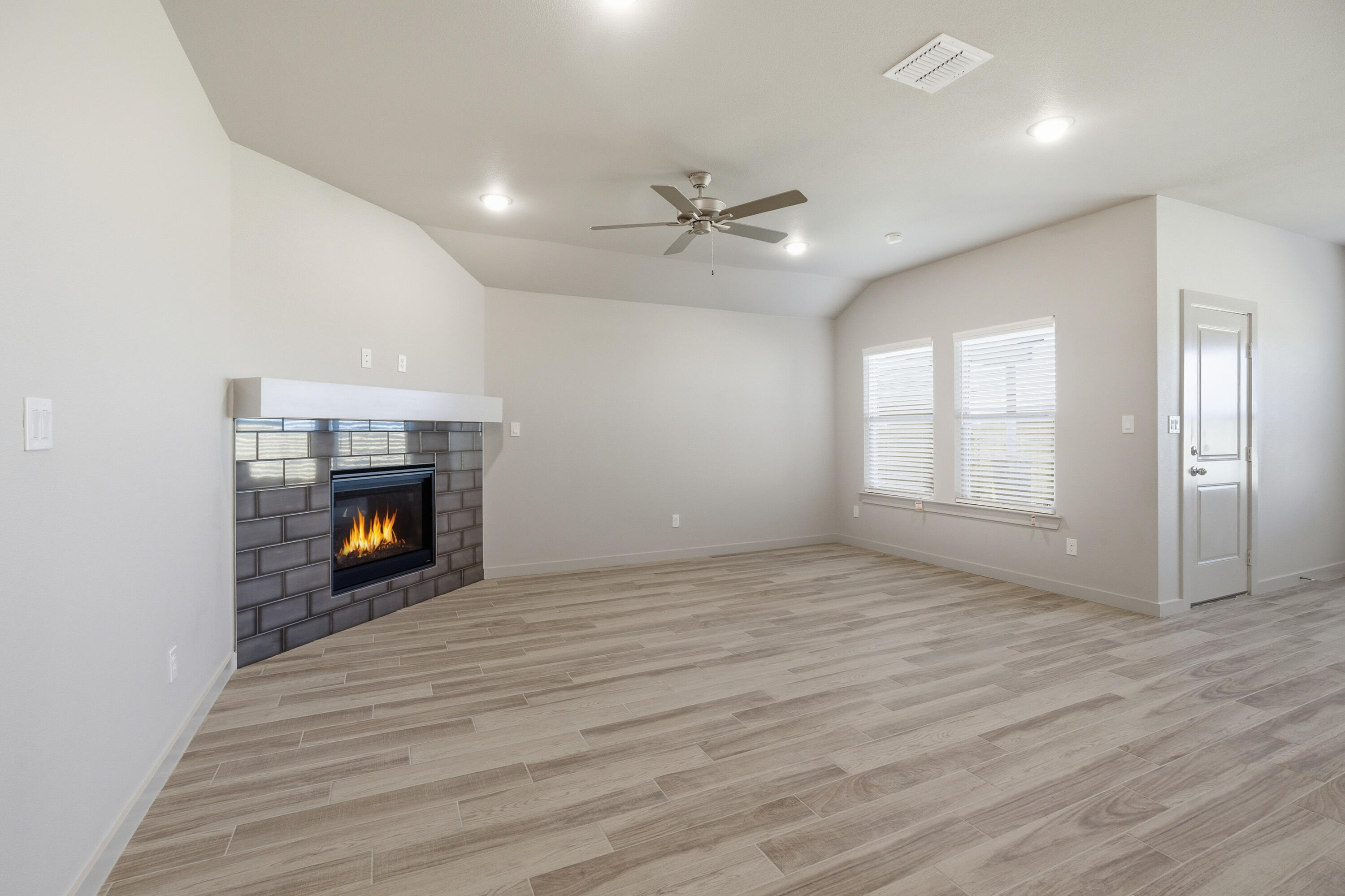 616 East 13th Street Wolfforth, TX 79382 - Photo 5 of 34 an empty room with windows and a fireplace