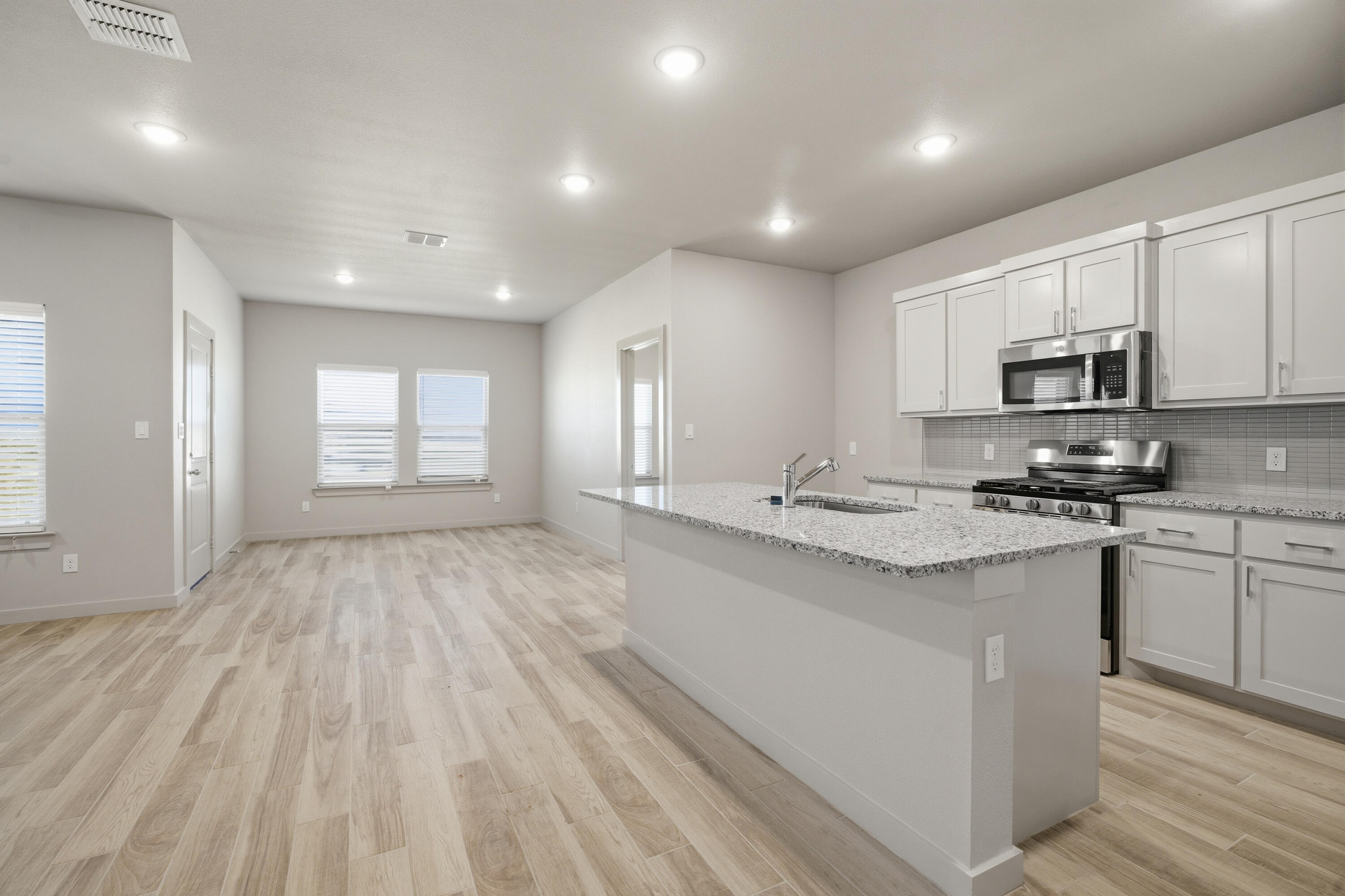 616 East 13th Street Wolfforth, TX 79382 - Photo 8 of 34 a kitchen with kitchen island granite countertop a sink cabinets and stainless steel appliances