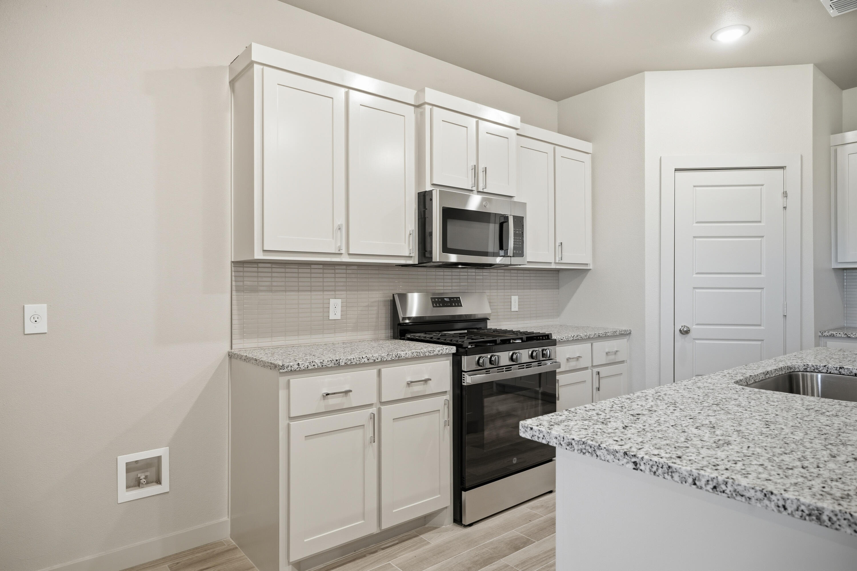 616 East 13th Street Wolfforth, TX 79382 - Photo 10 of 34 a kitchen with stainless steel appliances granite countertop a stove a sink and a microwave