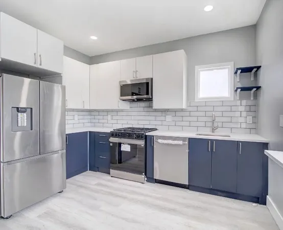a kitchen with granite countertop a refrigerator stove top oven and sink