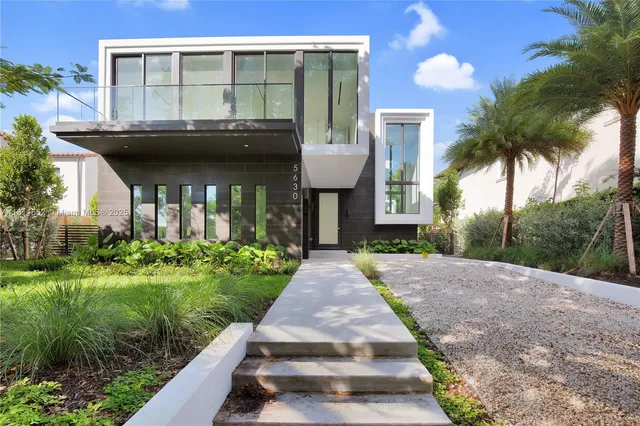 a front view of a house with a garden and plants