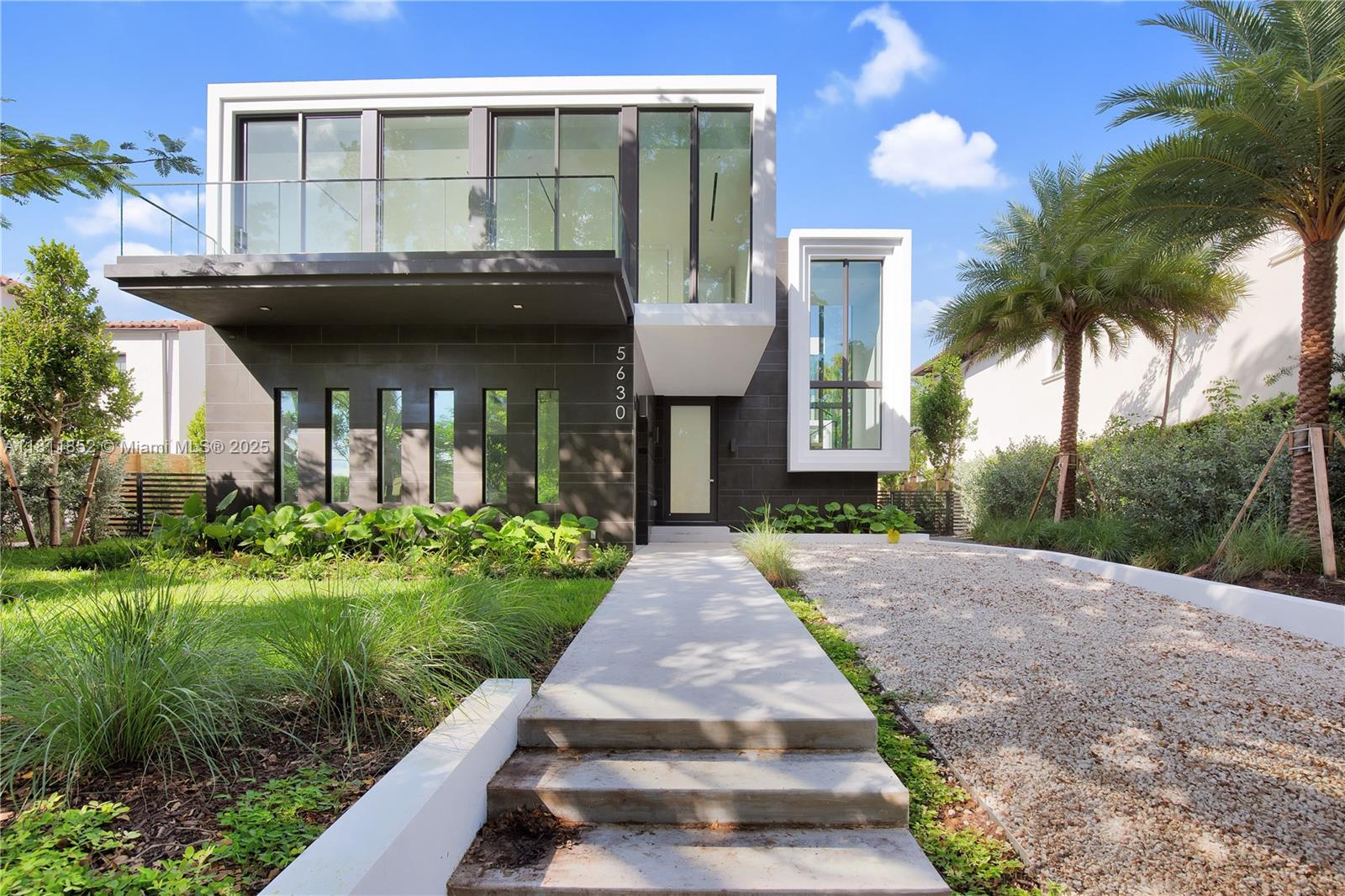 a front view of a house with a garden and plants