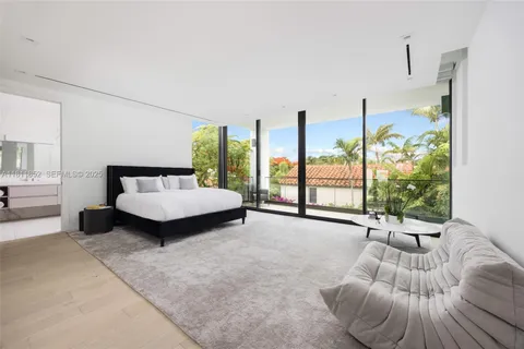 a bedroom with a bed and large window