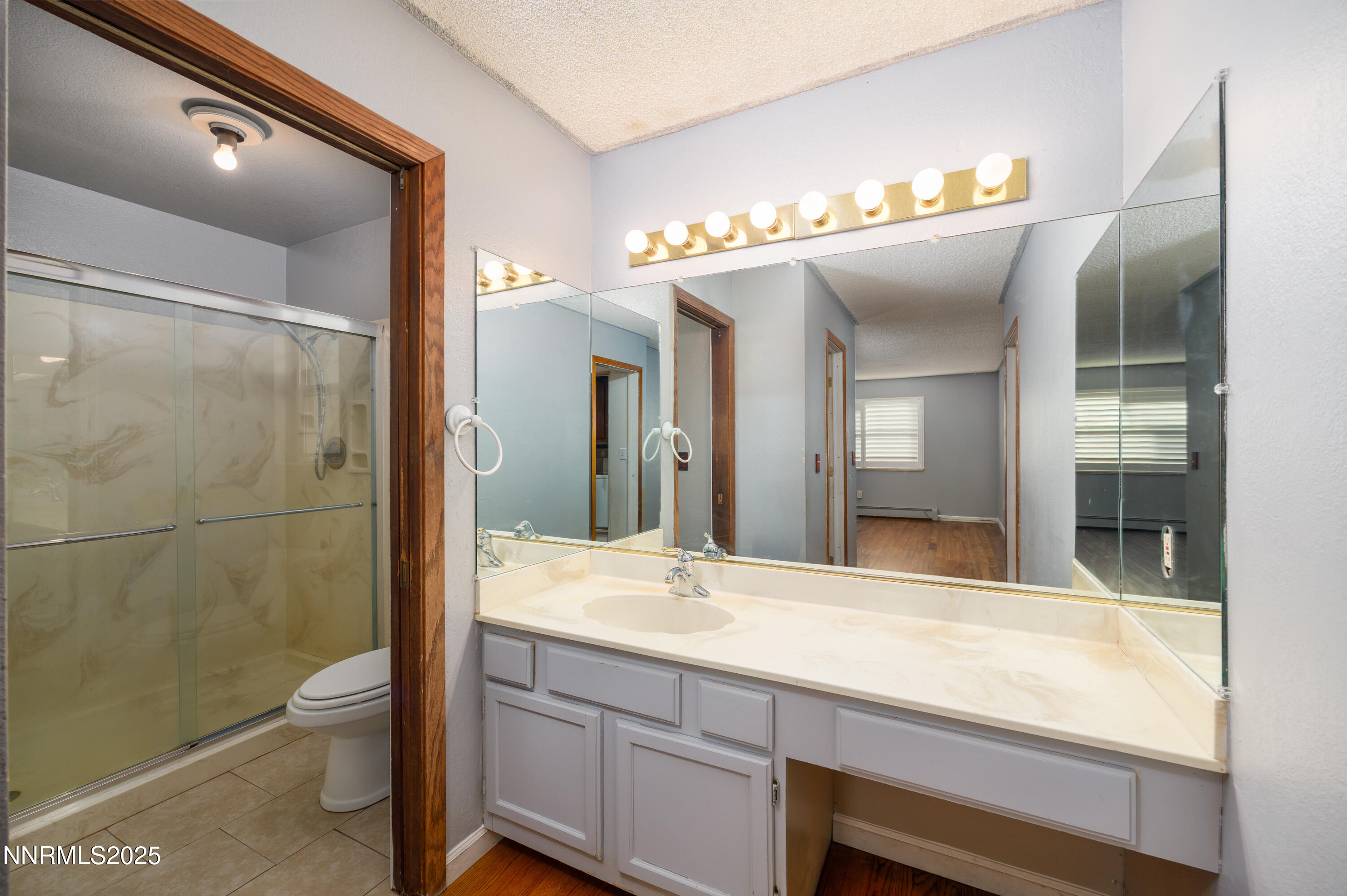 375 Hoge Road Reno, NV 89506 - Photo 10 of 36 a bathroom with a granite countertop sink a toilet a mirror and shower