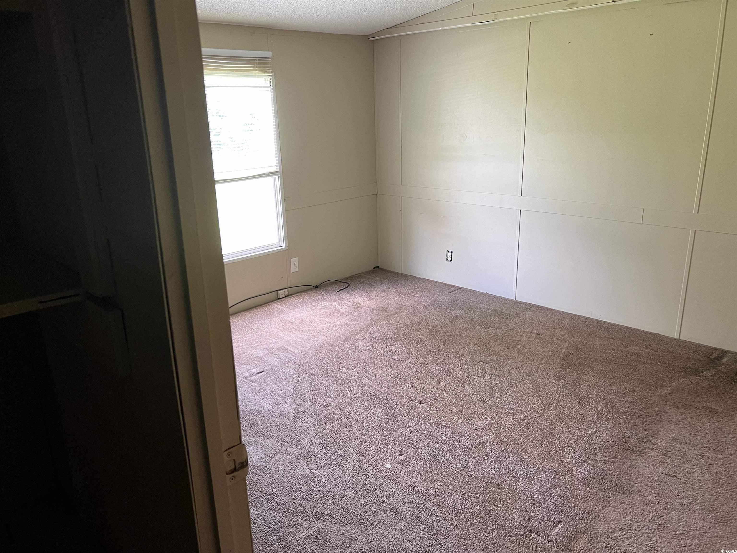 1118 Decatur Street Northeast Orangeburg, SC 29118 - Photo 8 of 14 Spare room featuring carpet floors and a textured ceiling