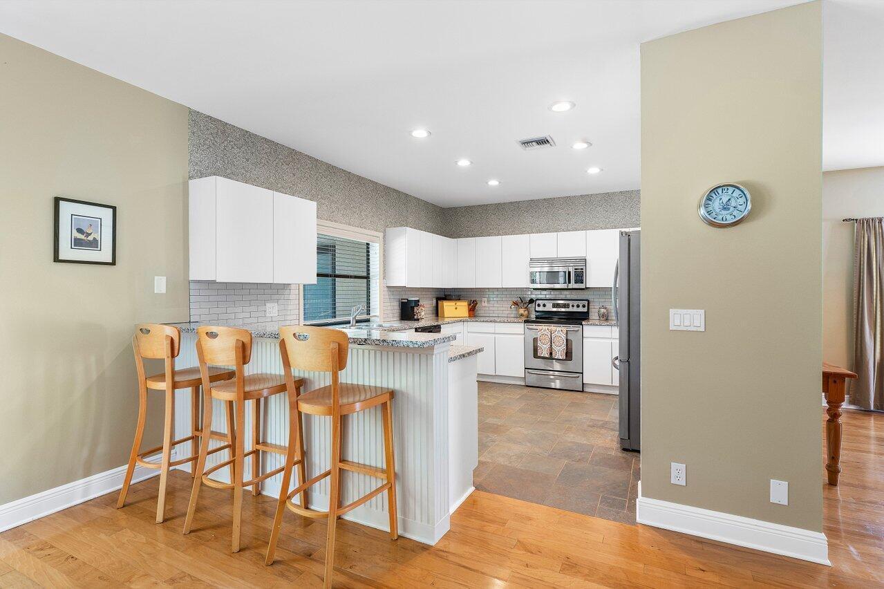 11842 Island Lakes Lane Boca Raton, FL 33498 - Photo 12 of 49 a kitchen with granite countertop white cabinets and stainless steel appliances