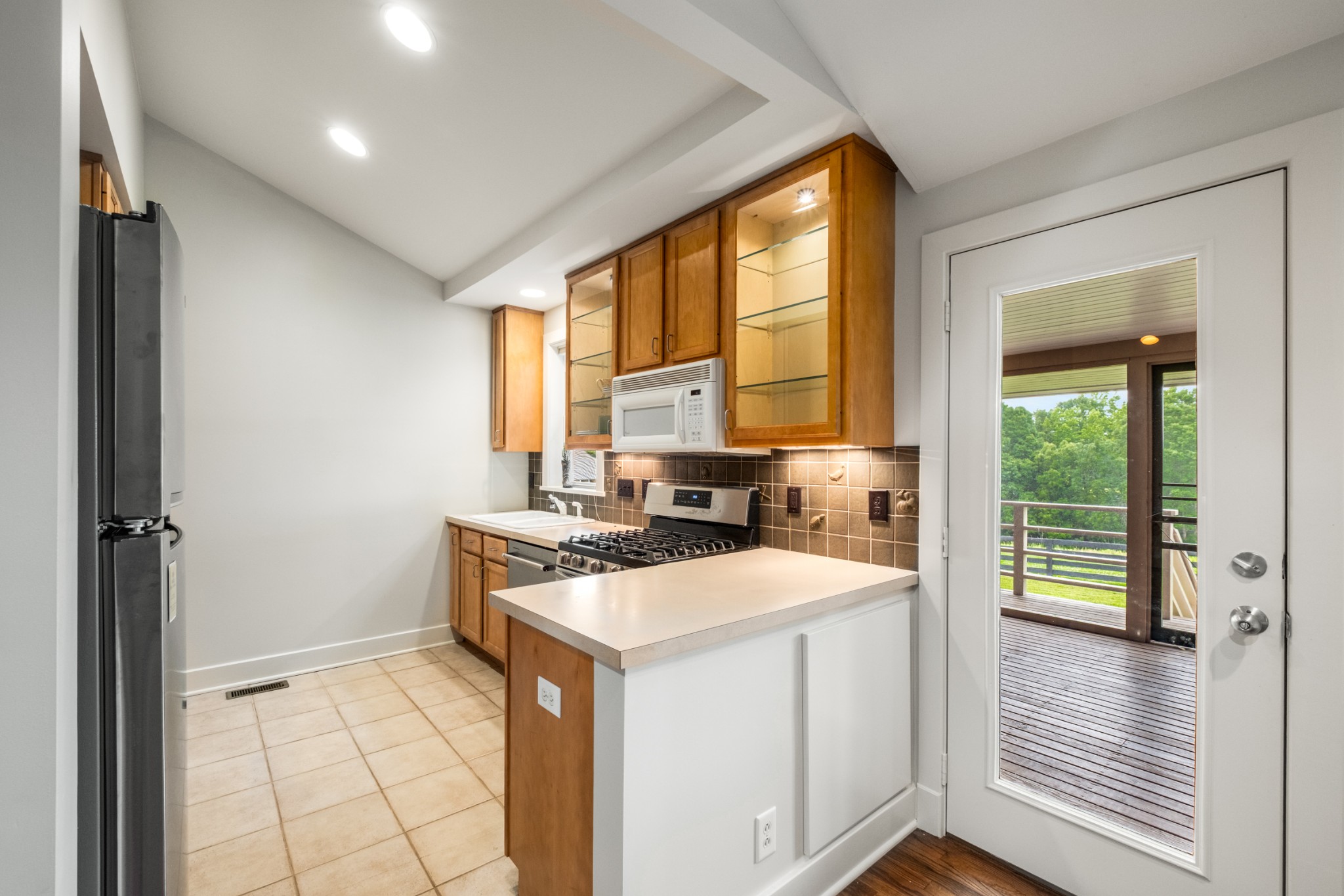 7909 Shoals Branch Road Primm Springs, TN 38476 - Photo 59 of 87 a kitchen with a stove a sink and a refrigerator