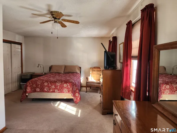 a bedroom with a bed dresser and a chandelier