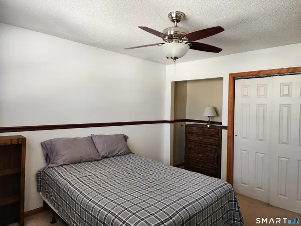 a bedroom with a bed and a ceiling fan