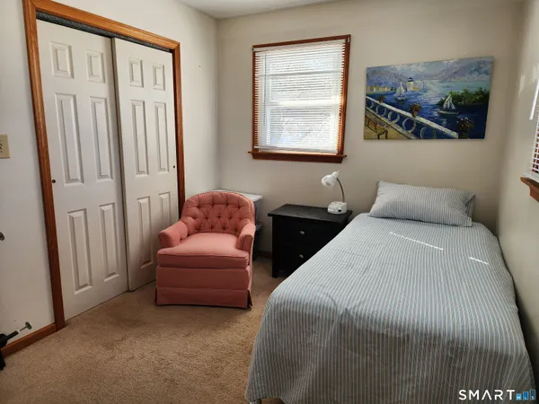 a bedroom with a bed and a painting on the wall