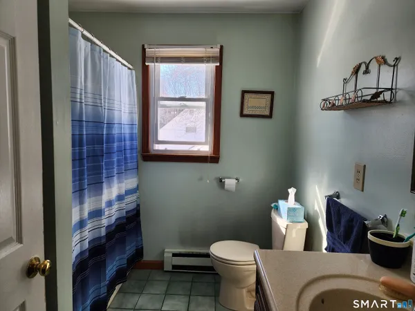 a bathroom with a toilet a sink and mirror