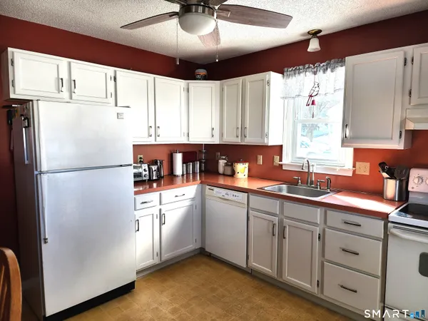 a kitchen with a refrigerator sink and cabinets