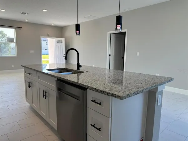 a kitchen with stainless steel appliances granite countertop a sink a stove and a refrigerator