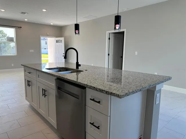 a kitchen with stainless steel appliances granite countertop a sink a stove and a refrigerator