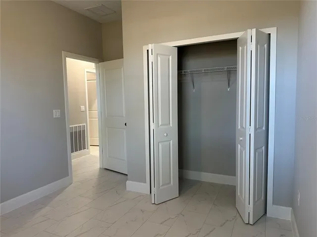 an empty room with closet and a bathroom