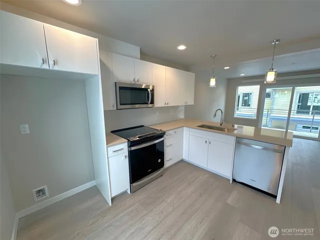 a large kitchen with a stove a sink and a microwave