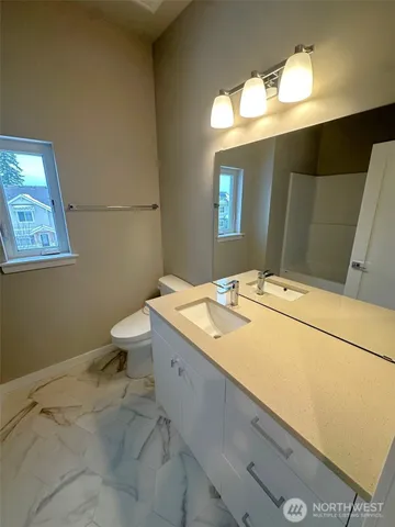 a bathroom with a sink a toilet and mirror