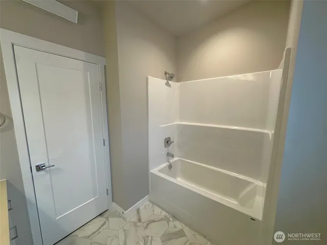 a white bath tub sitting next to a shower