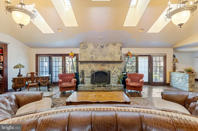 a living room with furniture a fireplace and a chandelier