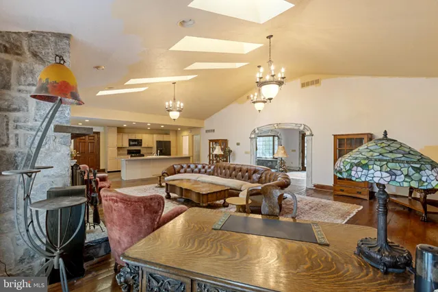 a living room with furniture a chandelier and a fireplace