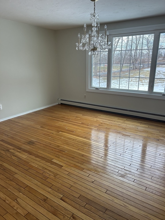 34 Uxbridge Road Sutton, MA 01590 - Photo 16 of 37 a view of empty room with wooden floor and chandelier