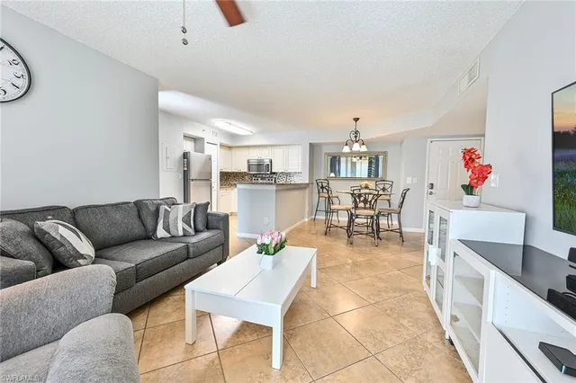 a living room with furniture and a dining table with kitchen view