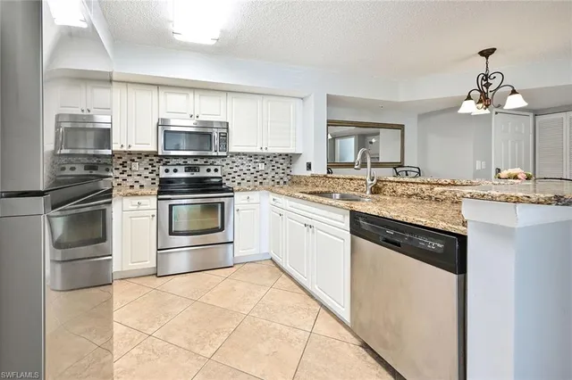 a kitchen with stainless steel appliances granite countertop a stove sink and cabinets