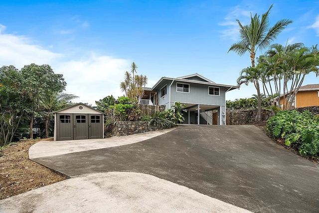 a front view of a house with a yard and potted plants