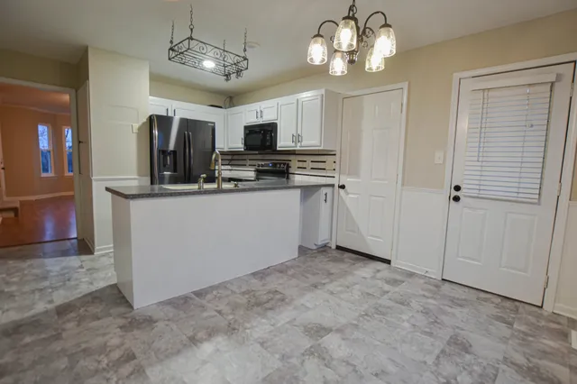 a view of a kitchen with a sink and refrigerator