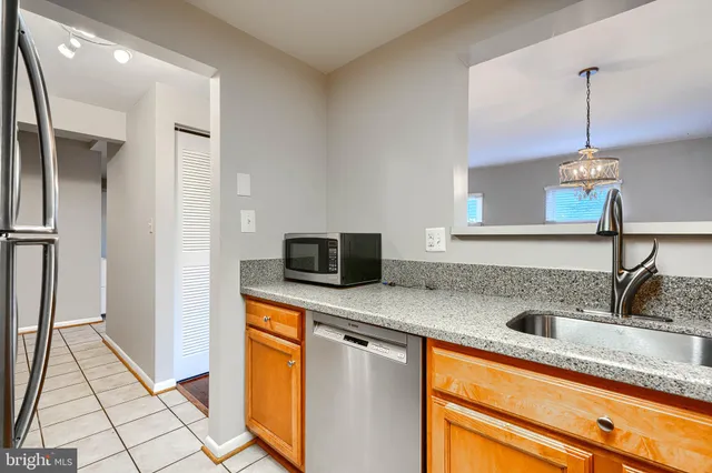 a kitchen with stainless steel appliances granite countertop a sink and a refrigerator