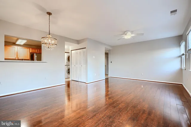 a view of a room with wooden floor chandelier and windows