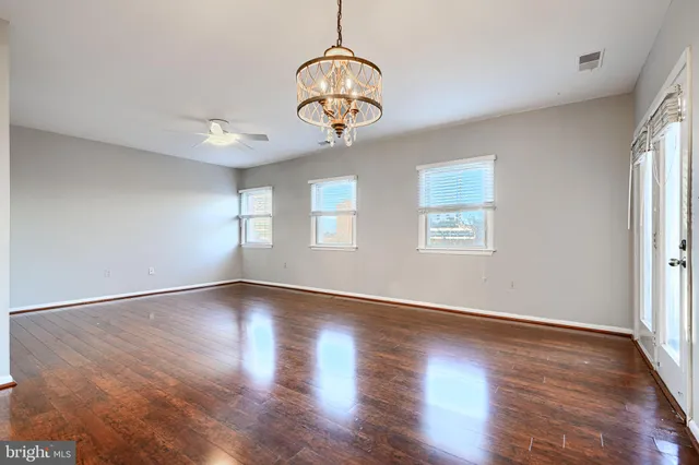 an empty room with wooden floor windows and view