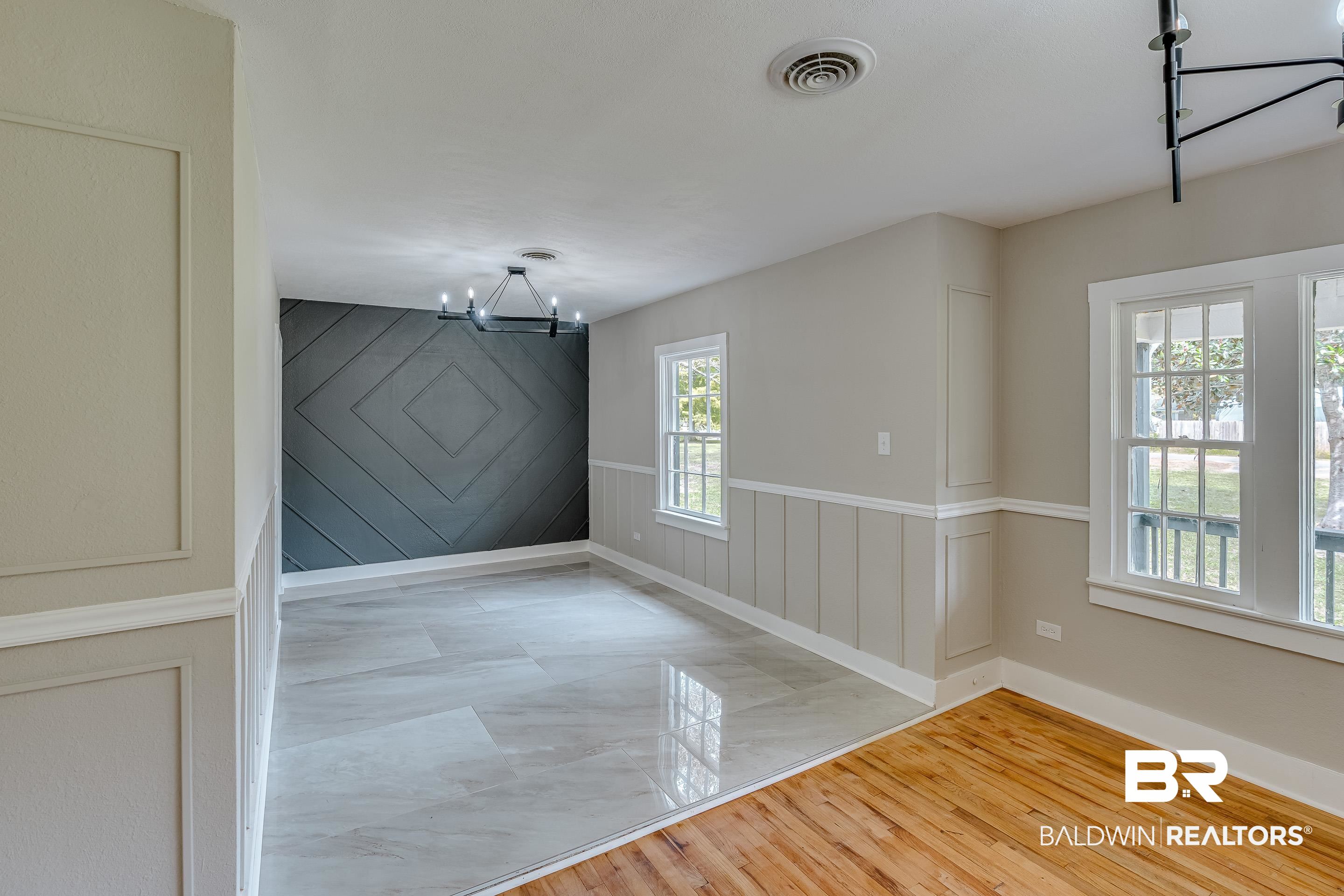 8001 16th Street Irvington, AL 36544 - Photo 6 of 35 Empty room featuring light wood-style flooring, a chandelier, and wood walls