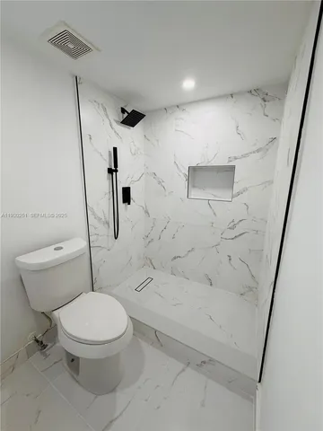 a white toilet sitting next to a bath tub