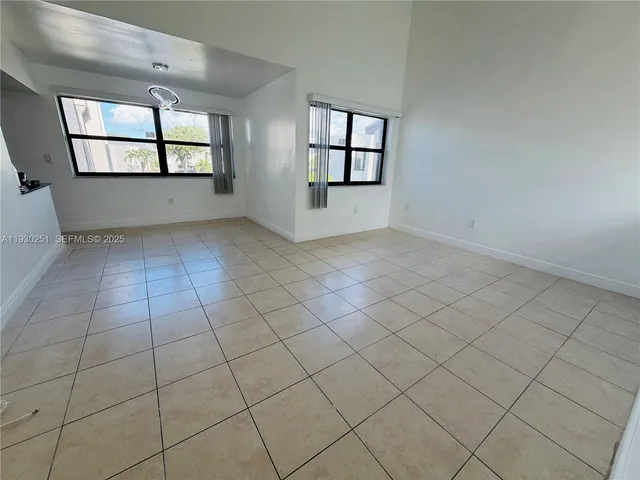 an empty room with windows and mirror