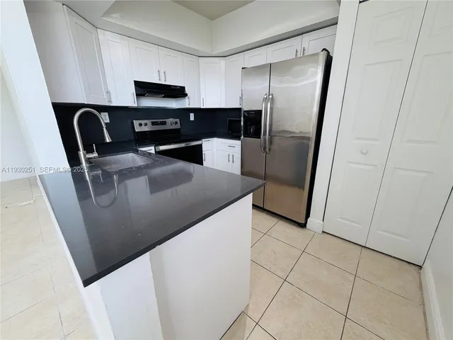 a kitchen with stainless steel appliances a refrigerator a sink a stove a microwave and cabinets