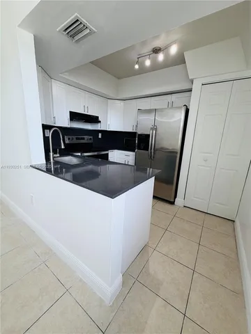a kitchen with stainless steel appliances a sink a stove a microwave a counter top and cabinets