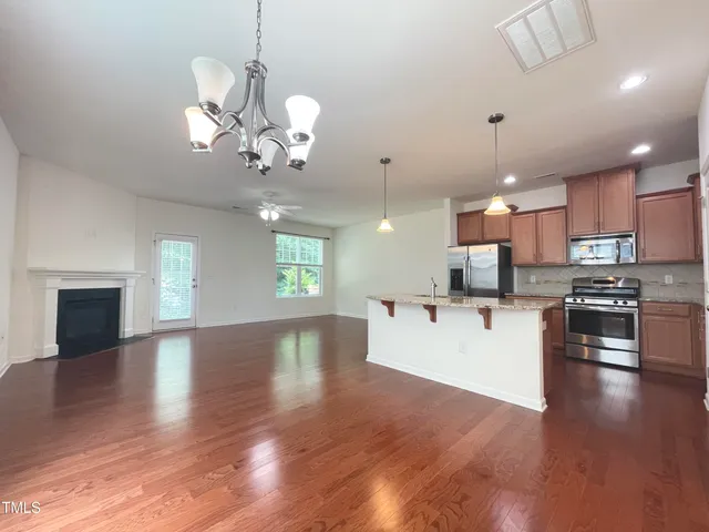 a view of a kitchen with stove and wooden floor