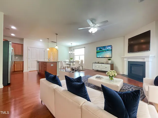 a view of an empty room with wooden floor and a fireplace