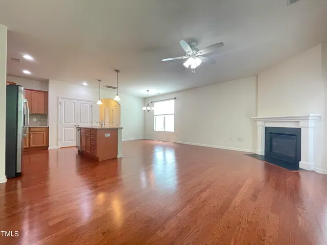 a view of a kitchen with a kitchen island wooden floor and a ceiling fan