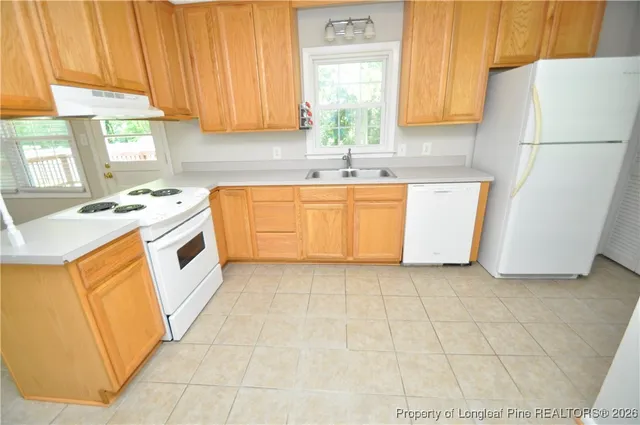 a kitchen with a sink a window and cabinets