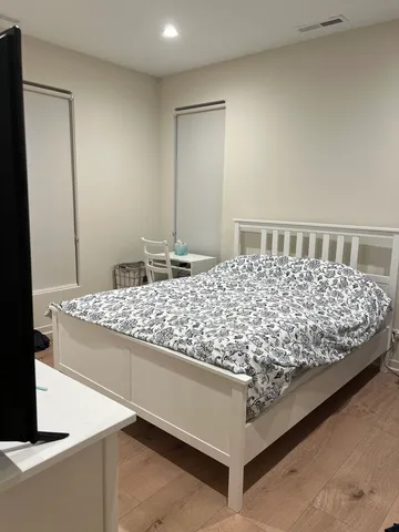 a bed sitting in a bedroom next to a bathroom sink